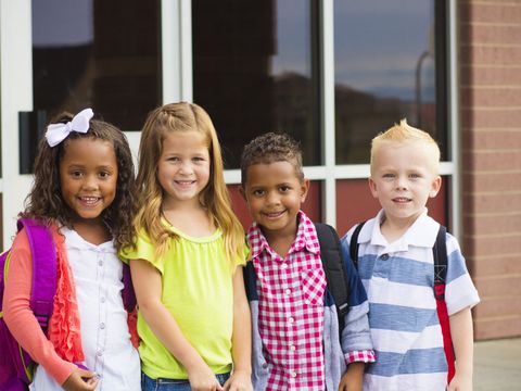 4 Kinder stehen vor einem Gebäude