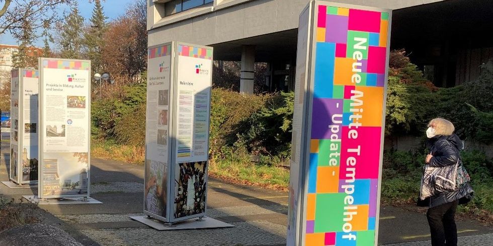 Säulen mit Texten "Neue Mitte Tempelhof - Update" und Grafiken auf einem Platz