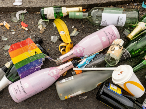 Müll am Straßenrand zusammen mit einer kaputten Papierregenbogenfahne