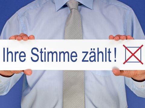 Mann hält Schild mit Schriftzug Ihre Stimme zählt