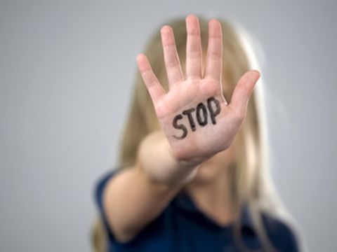 Frau hält Hand mit "STOP" Signal hoch