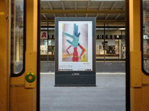 Plakat in einer U-Bahn-Station, gesehen durch geöffnete Türen
