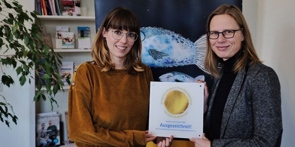 Bezirksstadträtin Carolin Weingart (l.) gratuliert Ute Clausner, Leiterin des STERNENFISCHER Freiwilligenzentrums, zum bagfa-Siegel