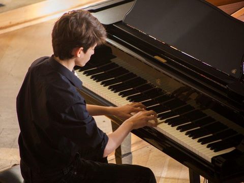 Junge spielt am Flügel