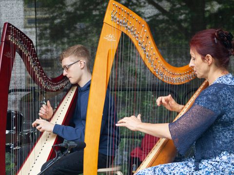 Zwei Menschen spielen Harfe auf einer Bühne