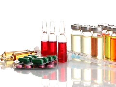 Ampullen, Spritzen und Tabletten liegen auf einem Tisch