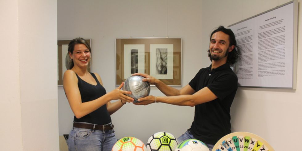 Foto : zwei Menschen werfen sich einen Ball zu