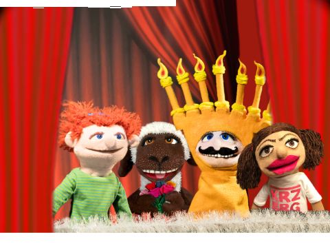 Vier Puppen stehen nebeneinander auf einer Puppenbühne