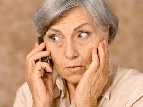 Ältere Frau mit Handy zuhörend