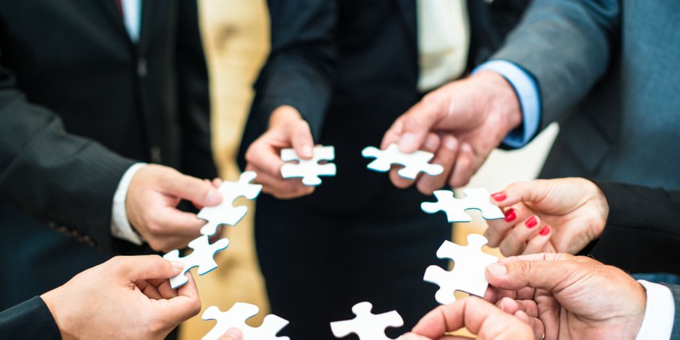 Mehrere Personen halten Puzzleteile zusammen