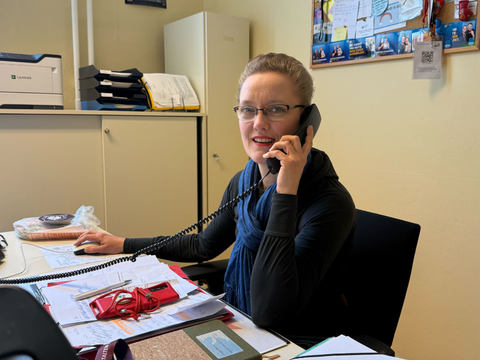Romana Wittmer sitzt am Schreibtisch und telefoniert - eine typische Geste, da Anfragen sie oft telefonisch erreichen.