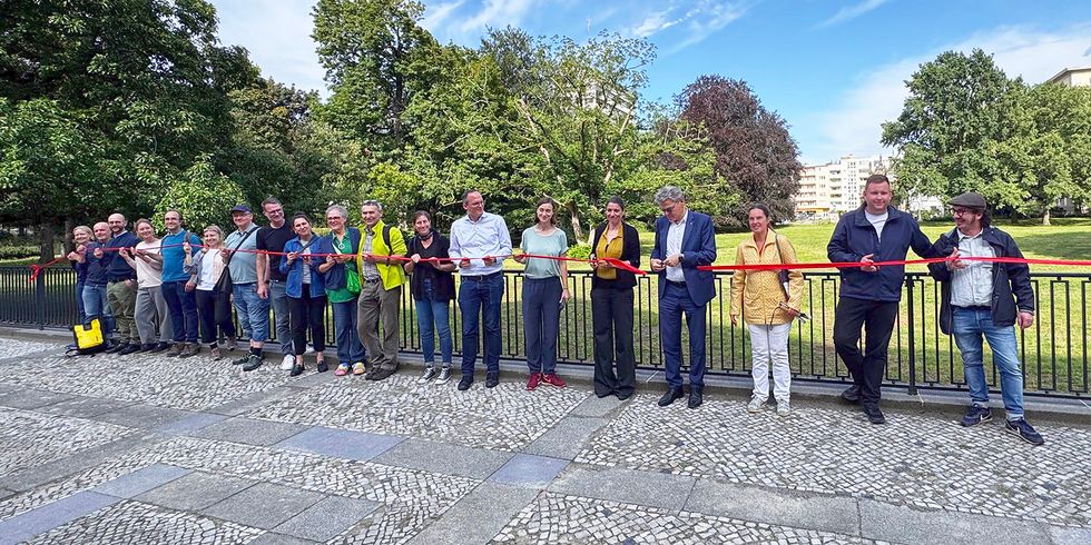 Eröffnung Heinrich-von-Kleist-Park: Alle Projektbeteiligten schneiden gemeinsam symbolisch ein rotes Band durch.