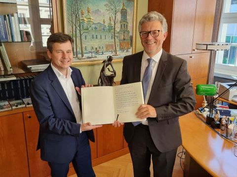 Bezirksbürgermeister Uwe Brockhausen (li.) übergibt das Reinickendorfer Solidaritätsbuch an Botschafter Dr. Andrij Melnyk. (Bild: BA Reinickendorf)