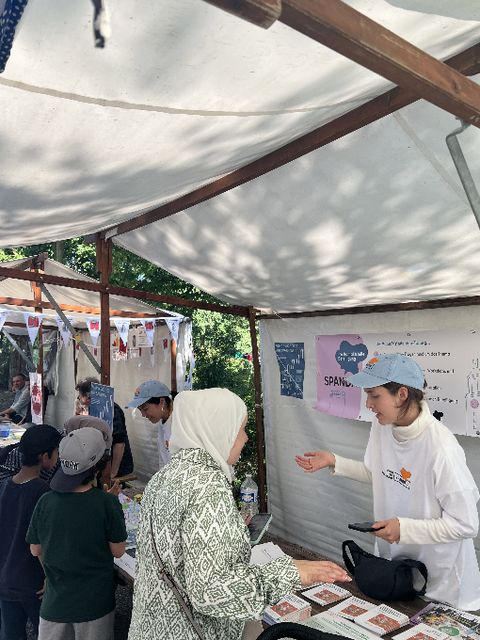 An einem Stand auf einem Kiezfest ist das Team des Raum für Beteiligung Spandau im Gespräch mit Besuchern und Besucherinnen