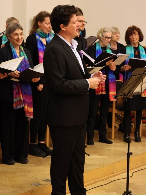 11. November 2025: Besticht durch seinen warmen Bariton - Kantor Hemi Levison, im Hintergrund der Shalom-Chor