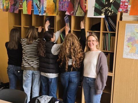 Schülerinnen der Klasse 6c räumen die neuen Fächer gemeinsam mit Schulleiterin Tabea Bartussek ein