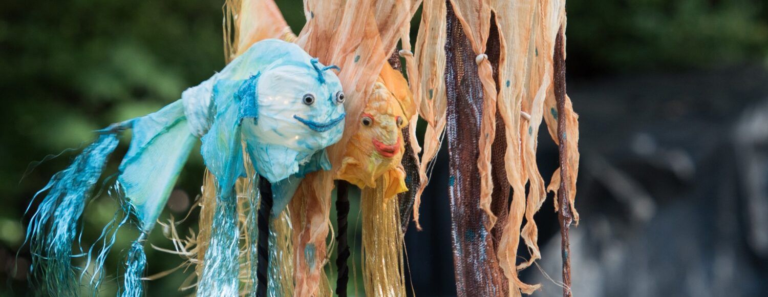 Fotografie von Fischfiguren, die für eine Theaterinszenierung eingesetzt werden.