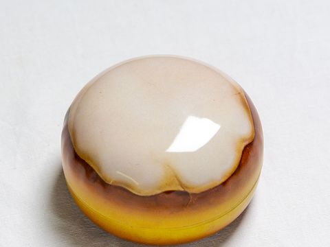 Eine Blechdose in Form und Farbe einem Berliner Pfannkuchen gleichend.
