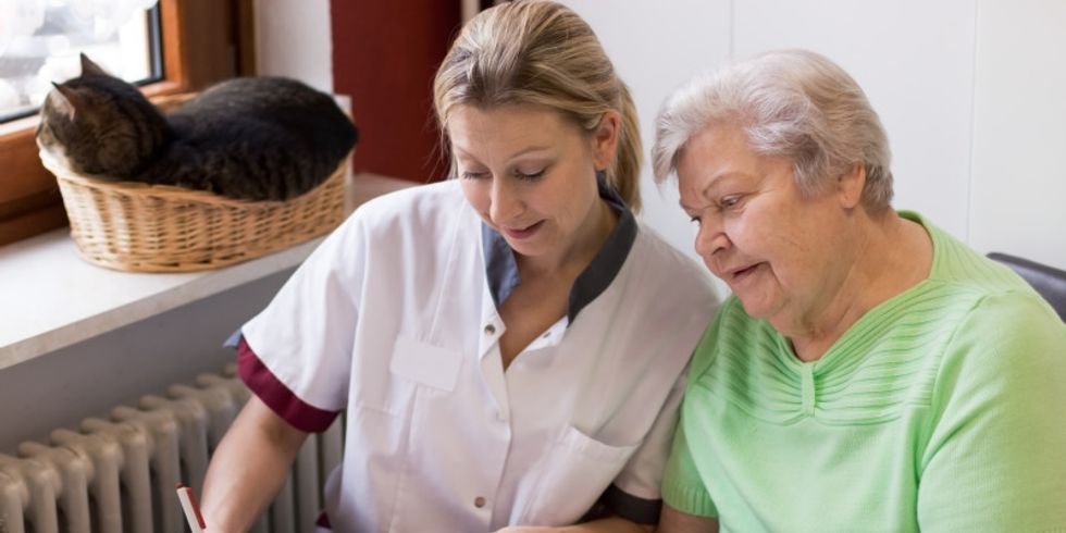 Altenpflegerin beim Hausbesuch einer Patientin