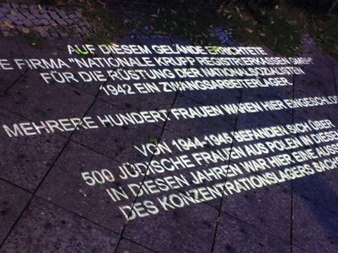 Lichtschriftprojektion auf die Straße Sonnenallee mit Angaben zum Zwangsarbeiterlager