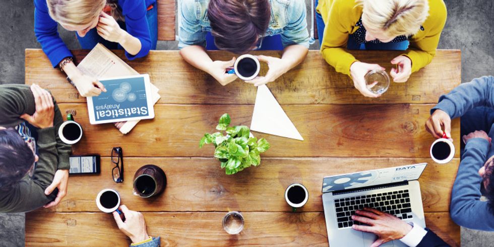 Menschen sitzen um einen Tisch