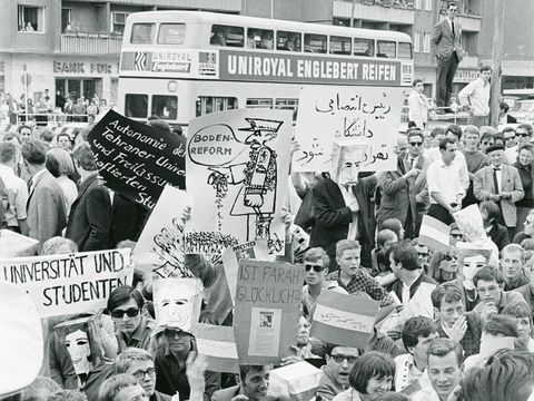 Anti-Schah-Proteste vor dem Rathaus Schöneberg beim Besuch des iranischen Herrschers Mohammad Reza Pahlavi in West-Berlin am 2. Juni 1967. Viele Demonstrierende haben sich Papiertüten mit den Konterfeis des Schahs und der Königin über den Kopf gestülpt. (Ausschnitt) (Bild: Jürgen Henschel, Museen Tempelhof-Schöneberg, Archiv)