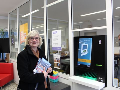 BzStR'in Richter-Kotowski testet die neue automatisierte Rückgabeanlage der Gottfried-Benn-Bibliothek. (Bild: Bezirksamt Steglitz-Zehlendorf)