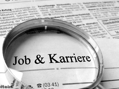 Zeitung mit Lupe über der Überschrift Job und Karriere