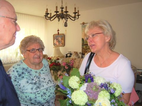 Ältere Frau mit Blumen in der Hand und älterer Mann