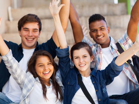 Fröhliche Schüler mit ausgestreckten Armen