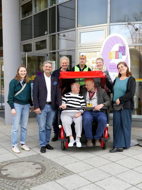 Einweihung des „Feuervogels“ am Stadtteilzentrum Schöneberg; stehende Personen von links nach rechts: Katja Wohner (Planungs- und Koordinierungsstelle Gesundheit), Bezirksstadtrat Oliver Schworck, Ralf Siemers (flotte Berlin e.V.), Cordyline Bartz (fLotte SoziaL), Ina Fuchs (Stadtteilzentrum Schöneberg), Stefanie Brummer (flotte SoziaL) und Besuchende
