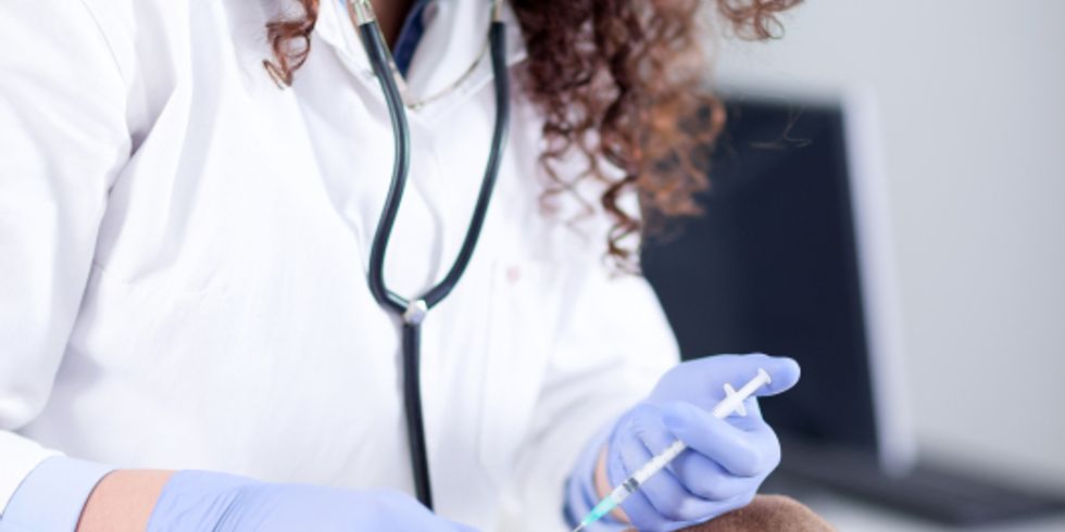 Tierärztin gibt einem jungen Hund der Rasse Shar-Pei eine Spritze