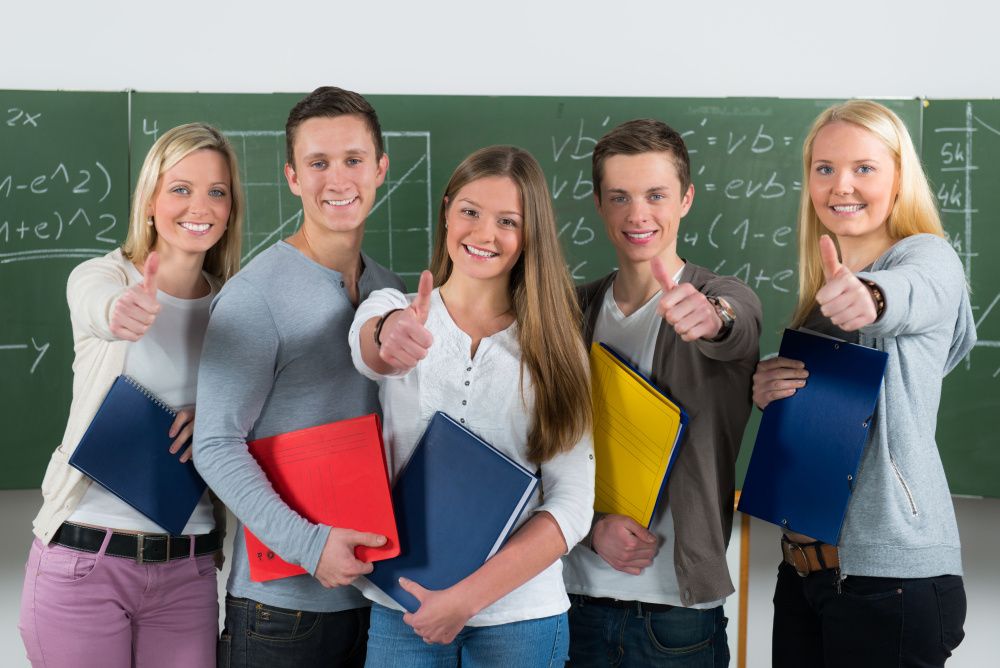 motivierte Schülergruppe zeigt Daumen hoch