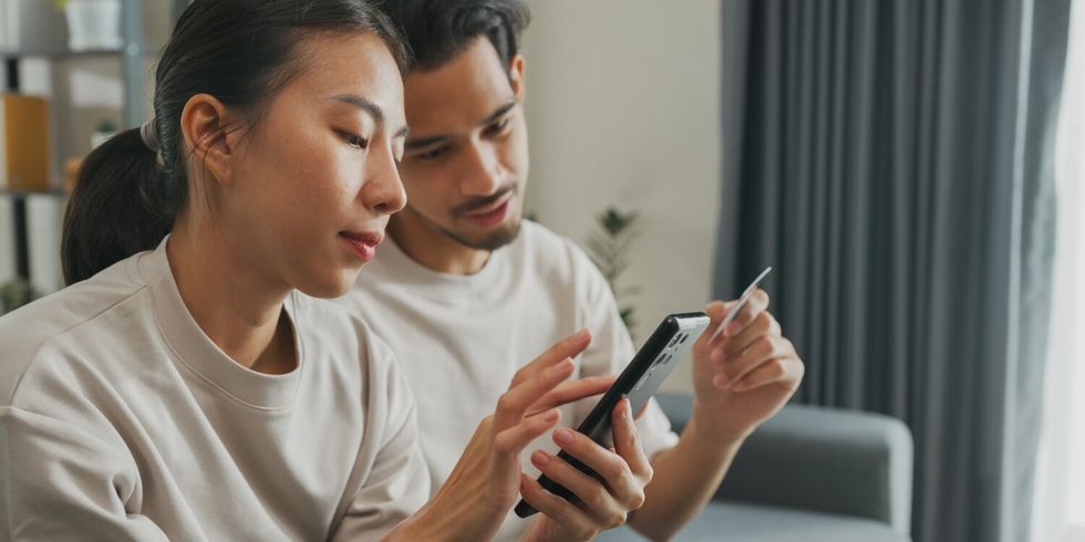 Ein Mann und eine Frau sitzen gemeinsam an einem Handy und bearbeiten etwas_2_1