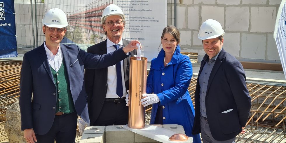 Präparieren den Grundstein für das Bauprojekt an der Quedlinburger Straße 45: (v.l.) LAF-Präsident Alexander Straßmeir, Staatssekretär Christian Gaebler, WBM-Geschäftsführerin Christina Geib und Charlottenburg-Wilmersdorfs Stadtentwicklungsstadtrat Fabian Schmitz-Grethlein.