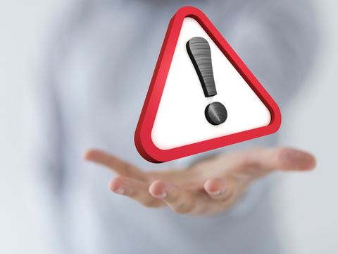 Warnschild schwebend über einer Hand