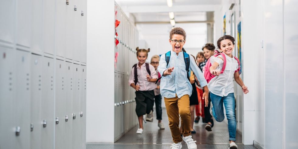 Schülerinnen und Schüler rennen über den Schulflur