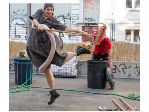 Eine Frau schwenkt tanzend einen Besen