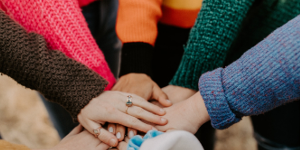 Nahaufnahme von aufeinander gestapelten Händen als Zeichen für Zusammenhalt und Teamwork.