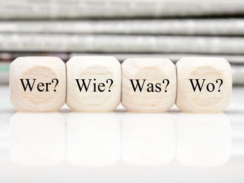 Vier Würfel mit den Fragen Wer? Wie? Was? Wo?