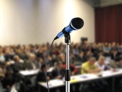 Mikrofon vor einem Hörsaal mit Menschen