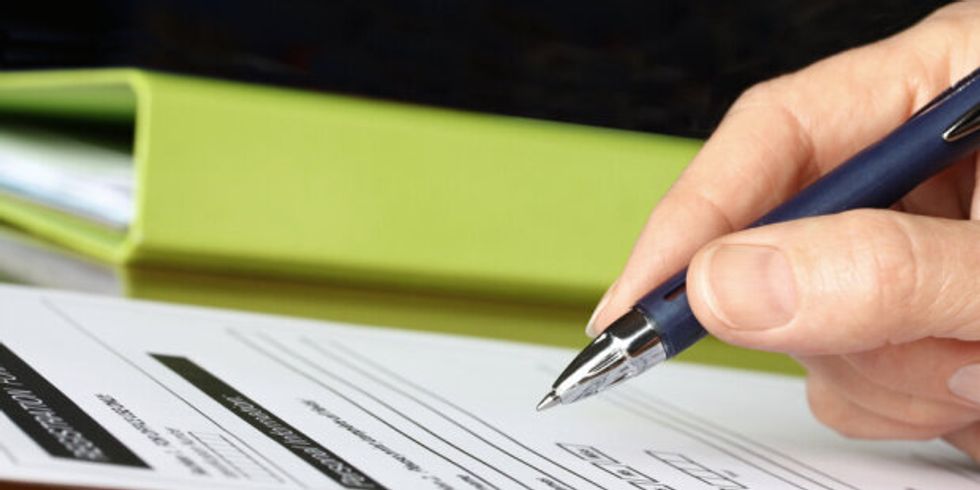 #29651462 - Hand with Pen Signing Form by Green Folder