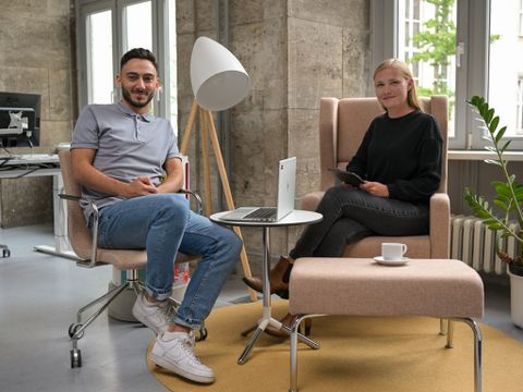 Zwei junge Steuerbeamten sitzen in einer Besprechungsecke