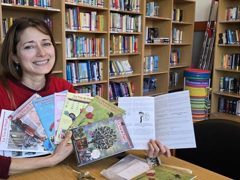 Publizistin Zulma Angélica Otálora-Nicklich zeigt in der Bibliothek der staatlichen Europaschule die Ausgaben der "La Voz de Papel"
