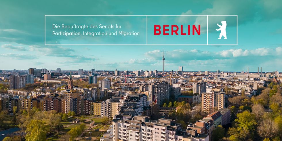 Berlin, Luftaufnahme des Bezirks Kreuzberg mit Fernsehturm im Hintergrund und Logo der Beauftragten des Senats von Berlin für Partizipation, Integration und Migration