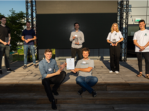 Gewinner:innen stehen verteilt auf Bühne und halten ihre Awards und Urkunden hoch