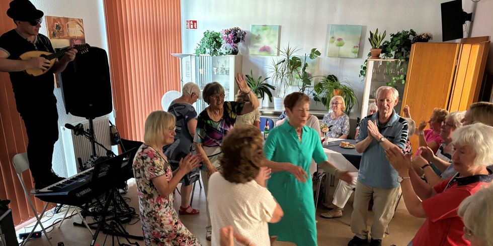 Musiker Danilo Rogoli spielt - auf dem Stuhl stehend - Evergreens und Italo-Pop für die Gäste des Sommerfestes