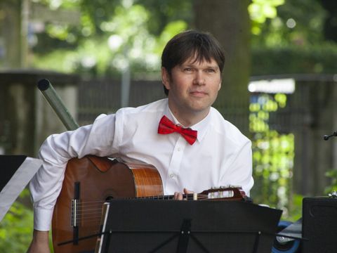 Mann spielt Gitarre im Freien