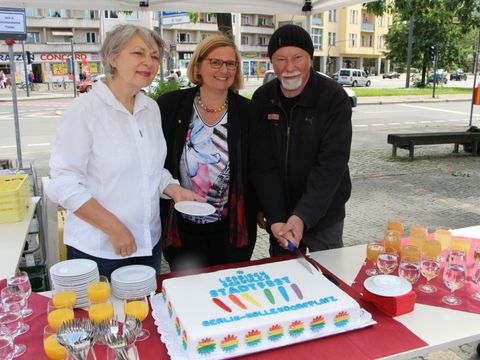 V.l.n.r.: Dr. Elisabeth Ziemer (ehemalige Bezirksbürgermeisterin von Schöneberg), Angelika Schöttler (Bezirksbürgermeisterin von Tempelhof-Schöneberg) und Gerhard Hoffmann (Regenbogenfonds e. V.) schneiden die Torte an. (Bild: Pressestelle Tempelhof-Schöneberg)