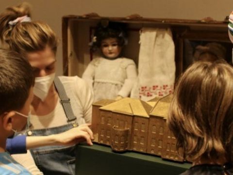 Frau und vier Kinder schauen in eine Kiste rein.